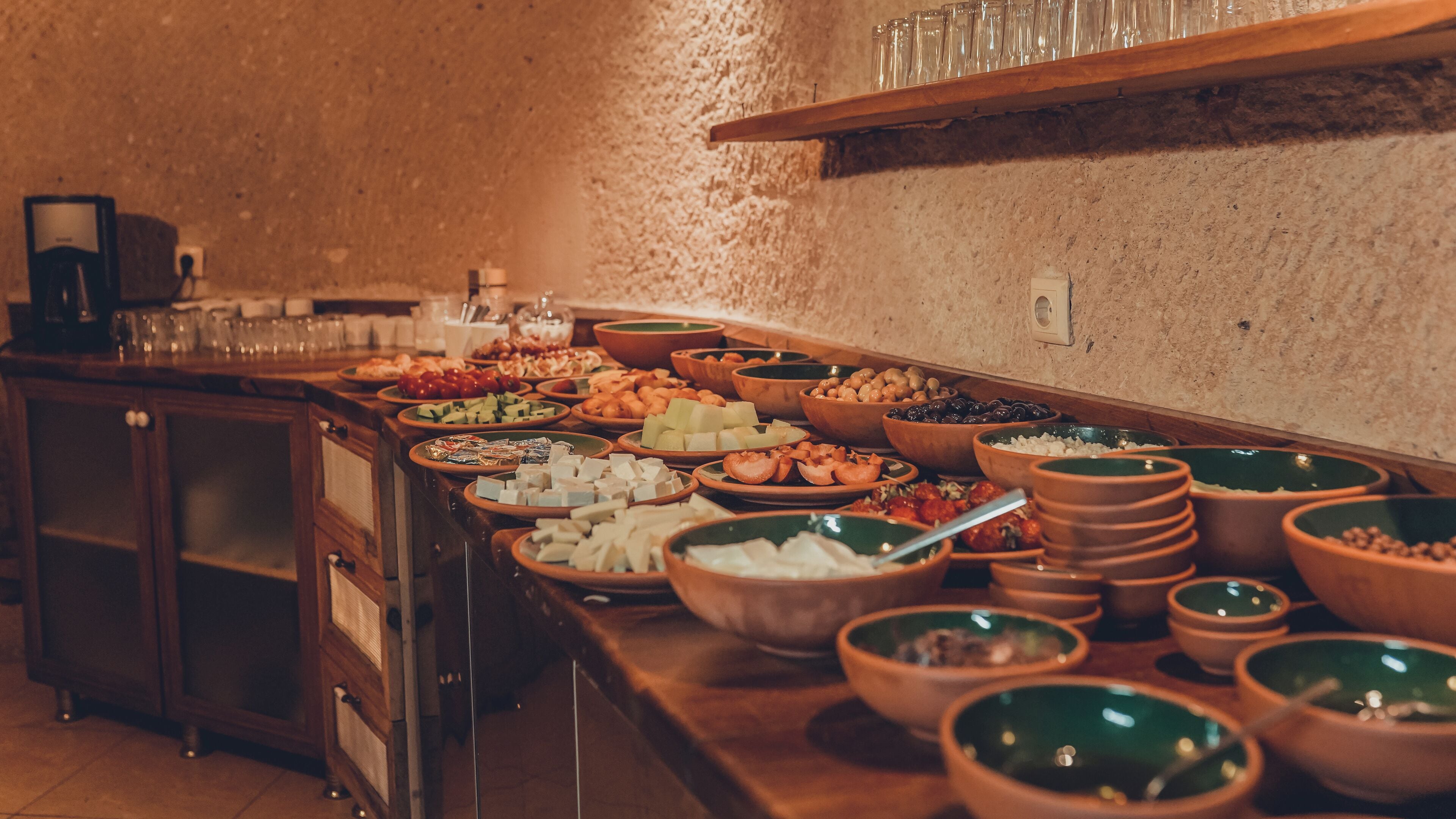 Un buffet proposant divers plats et des saladiers disposés sur une table en bois.