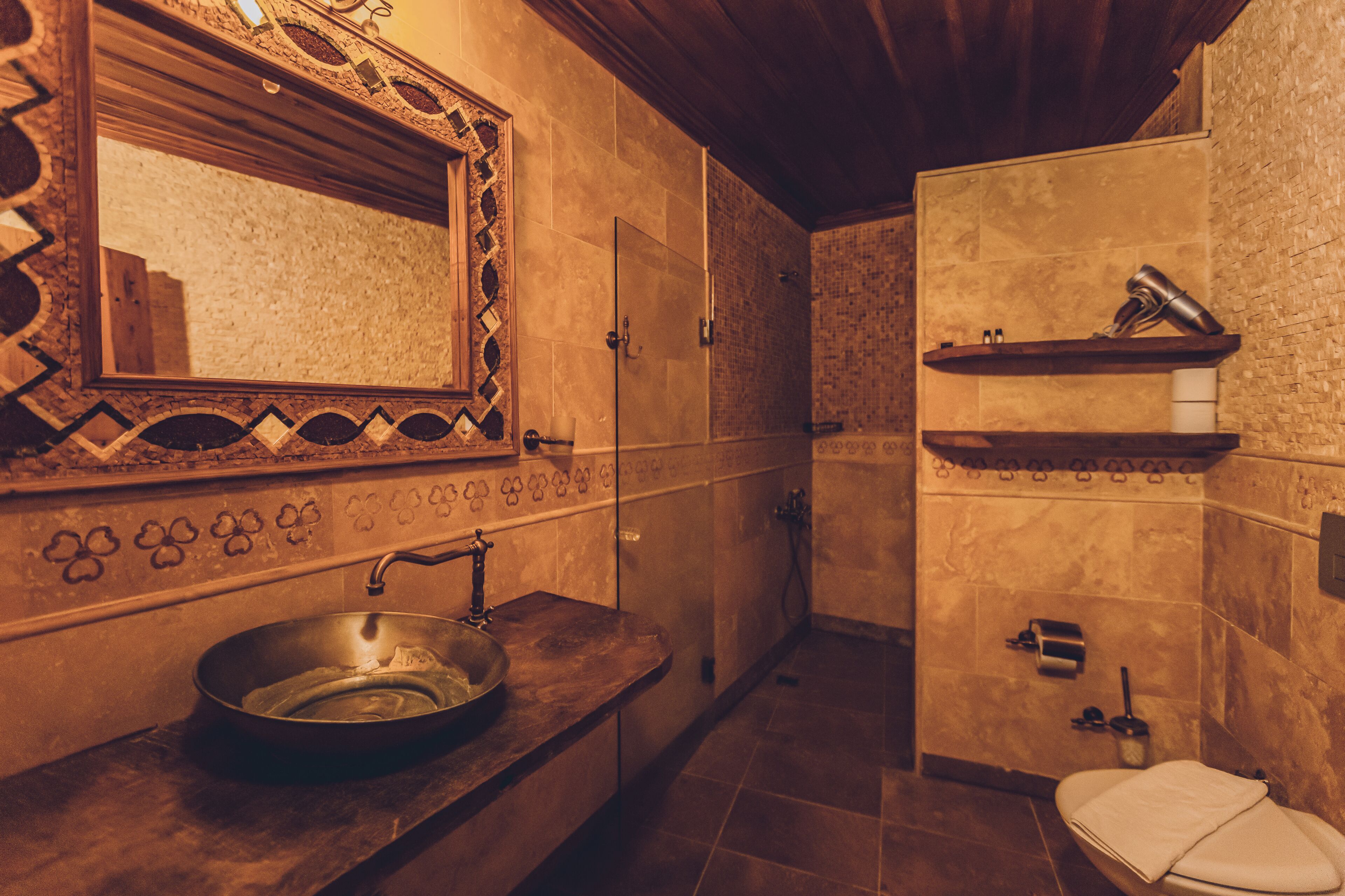 A bathroom with a sink, mirror, shower, and toilet.