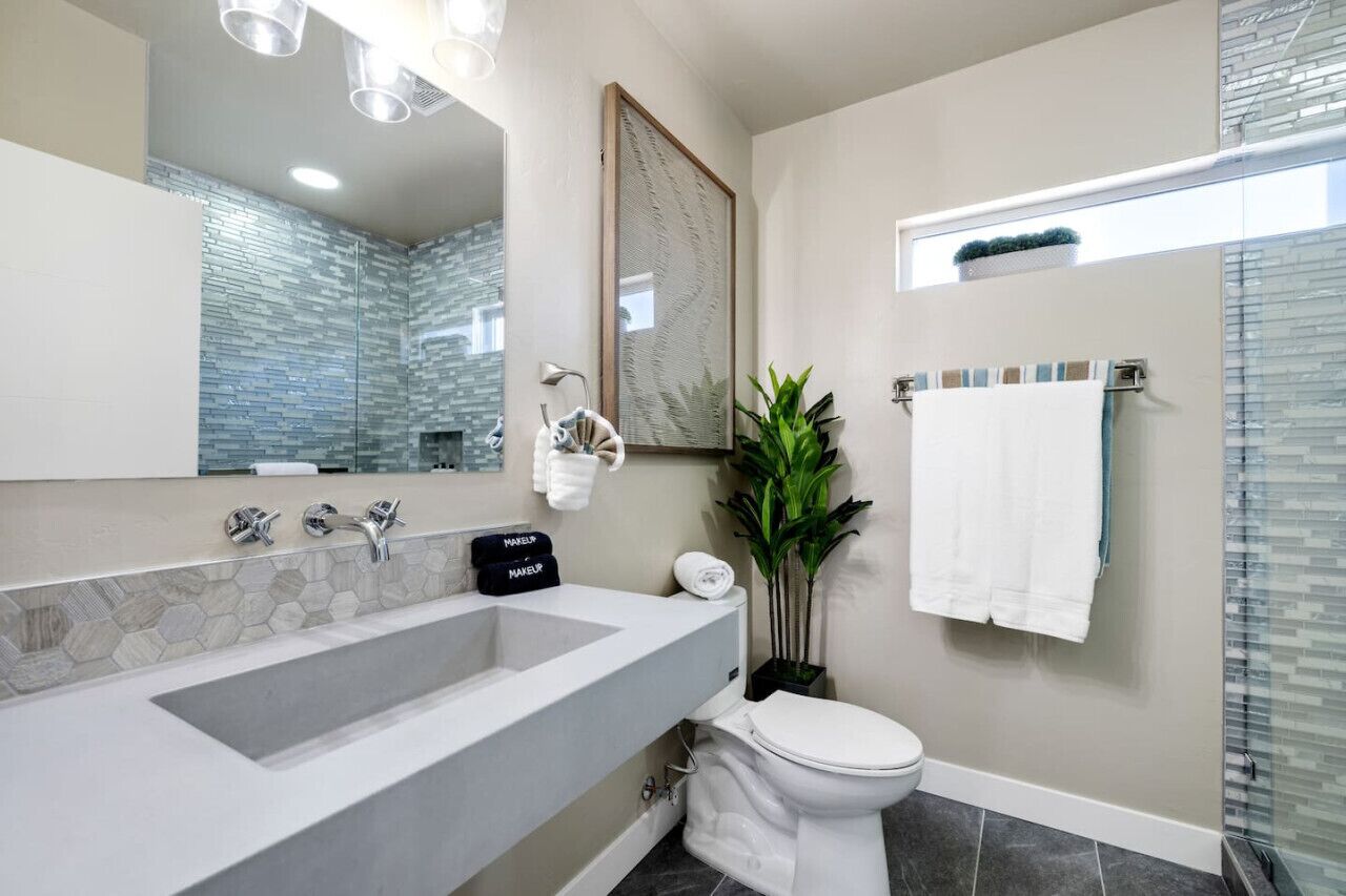 Un baño moderno con una bañera grande, un inodoro y una zona de ducha.