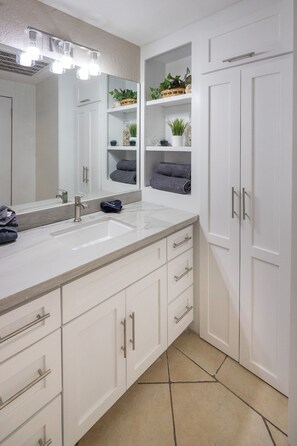 A modern bathroom with a large mirror, two sinks, and built-in storage cabinets. - Super Beachfront Condo Ground Level on Sandy Beach (Puerto Peñasco)