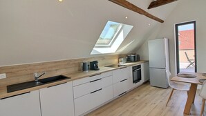 A modern kitchen with white cabinets, a wooden countertop, and a skylight. - Charming 3-bedroom house in the vineyard with terrace (Vœgtlinshoffen)