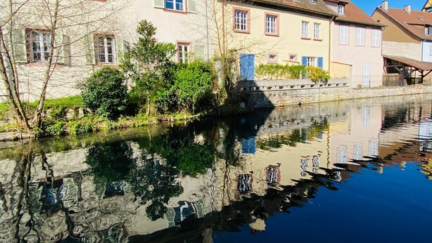 A canal with buildings on one side and a stone bridge in the middle. - Charming 3-bedroom house in the vineyard with terrace (Vœgtlinshoffen)