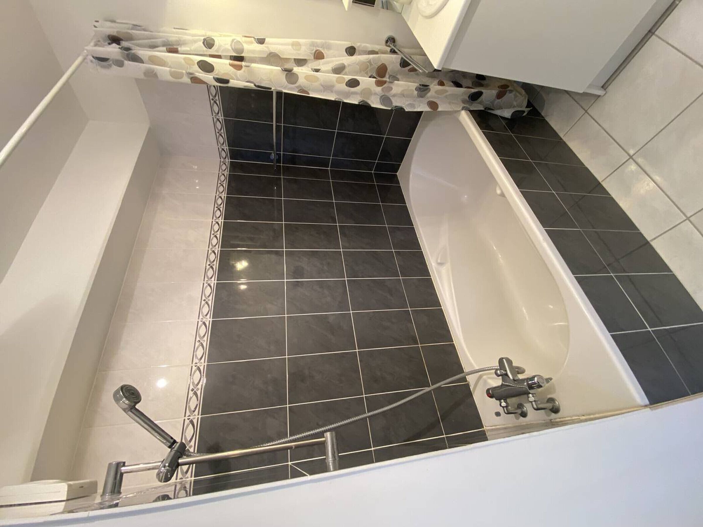 A modern bathroom with a bathtub, a shower area, and a toilet.
