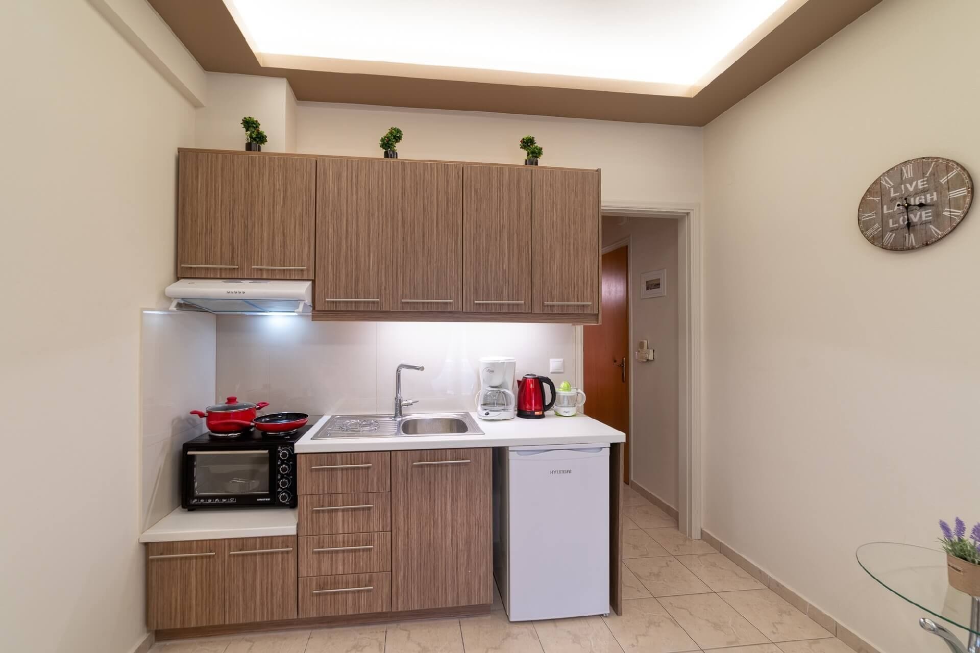A compact kitchen with wooden cabinets, a microwave, a dishwasher, and a coffee maker.