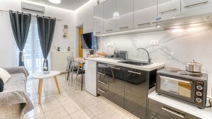 Eine moderne Küche mit Backofen, Spüle und Essbereich inklusive Tisch und Stühlen.