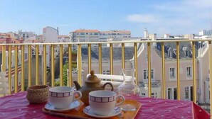 A balcony with a table set for tea, overlooking a cityscape. - Spacieux et Lumineux T2 au Cœur de Biarritz Proche e la Plage + Parking Privatif (Biarritz)