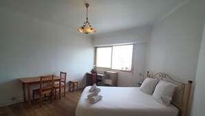 A bedroom with a bed, a desk, a chair, and a window. - Spacieux et Lumineux T2 au Cœur de Biarritz Proche e la Plage + Parking Privatif (Biarritz)