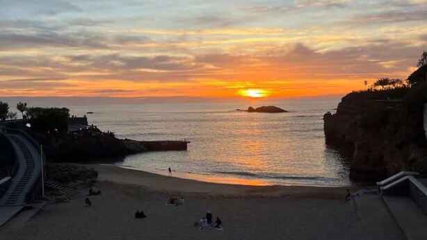 A beach with a sunset, a rocky coastline, and a staircase leading down to the beach. - Spacieux et Lumineux T2 au Cœur de Biarritz Proche e la Plage + Parking Privatif (Biarritz)