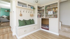 Una habitación con un banco empotrado, estanterías y una zona de estar acogedora con una alfombra.