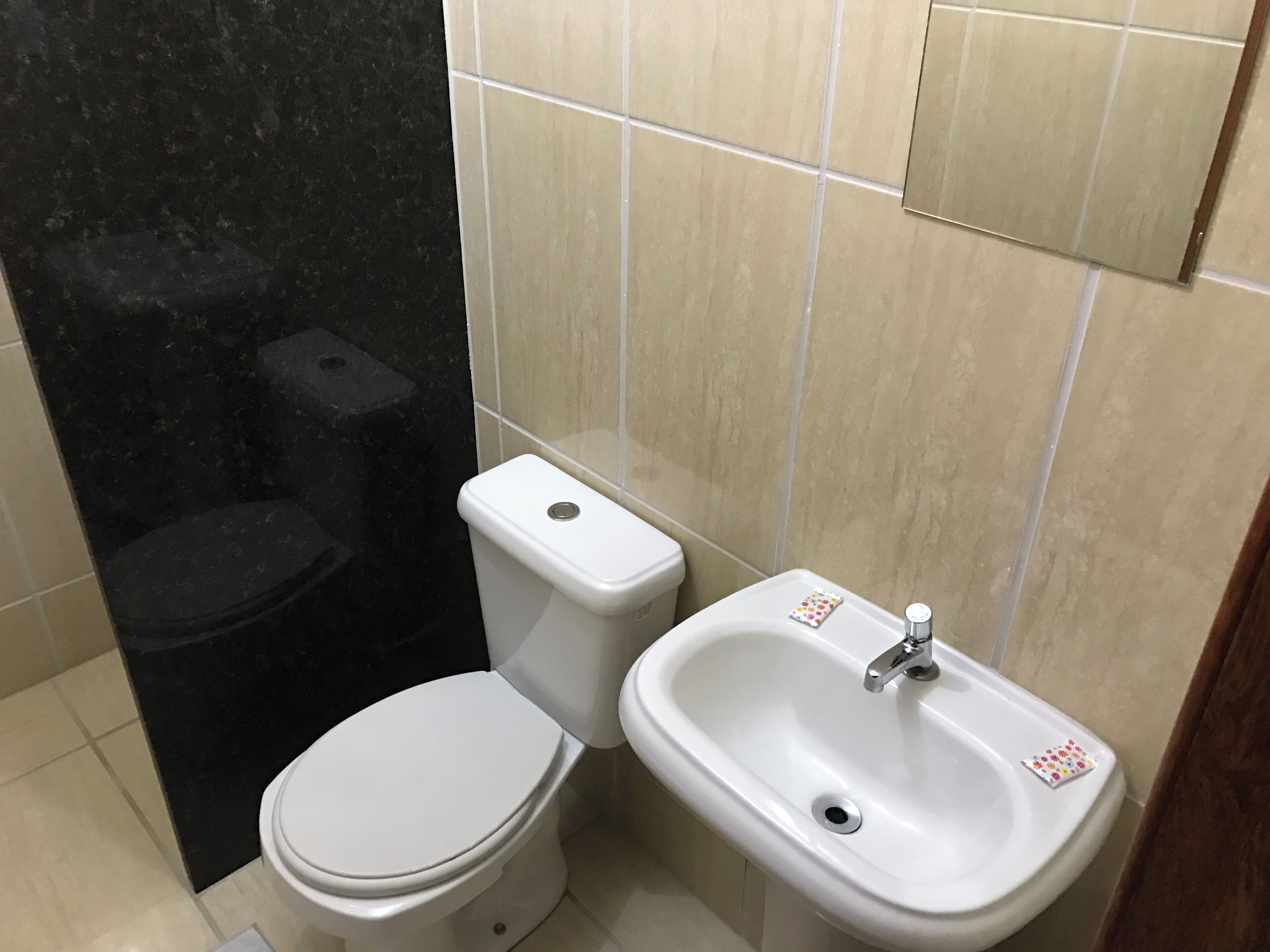 Casa de banho com sanita, bidé e lavatório.