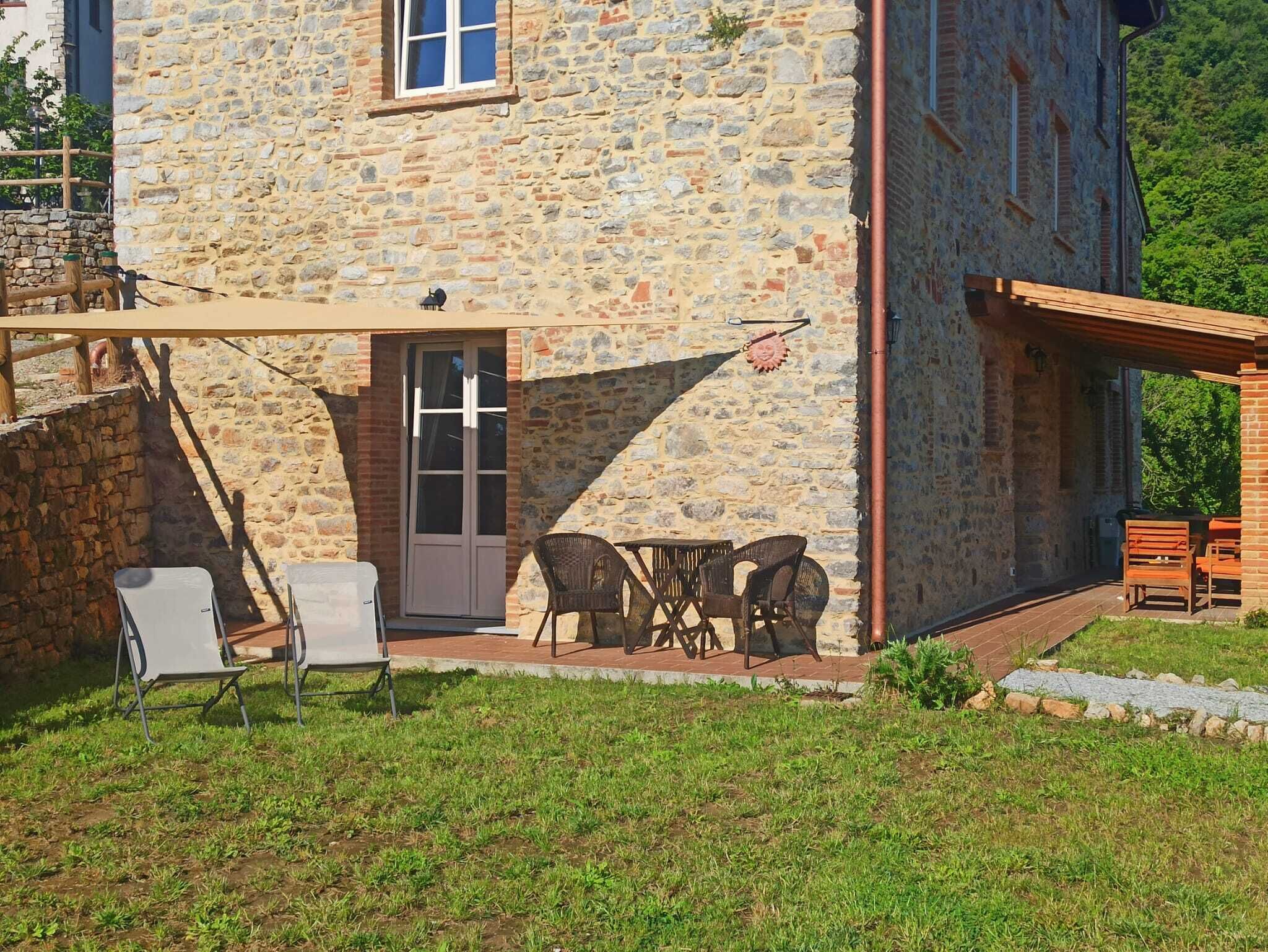 Edificio de piedra con patio amoblado y una puerta.