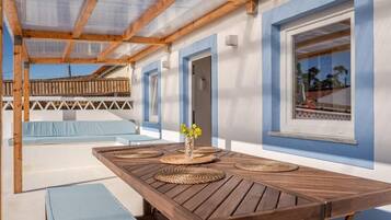 Relax on the patio with a view of the surrounding landscape, surrounded by a wooden table and a vase with fresh flowers.