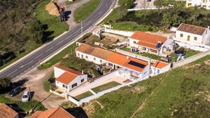An aerial view of a residential area with houses, a road, and a construction site. - Cottage in Aljezur- 2 bed Ensuite-casinha da Ivone (Aljezur)