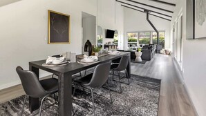 A modern dining area with a long table, black chairs, and a black and white patterned rug. - Golf View Home with Fire Pit & BBQ (Flagstaff)
