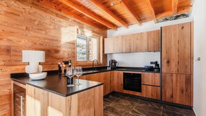Una cucina con mobili in legno, un piano di lavoro nero e una finestra.