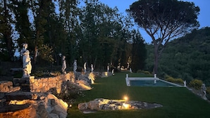 A landscaped garden with statues, a swimming pool, and a stone wall. - tenuta castel dell'aquila (Fivizzano)