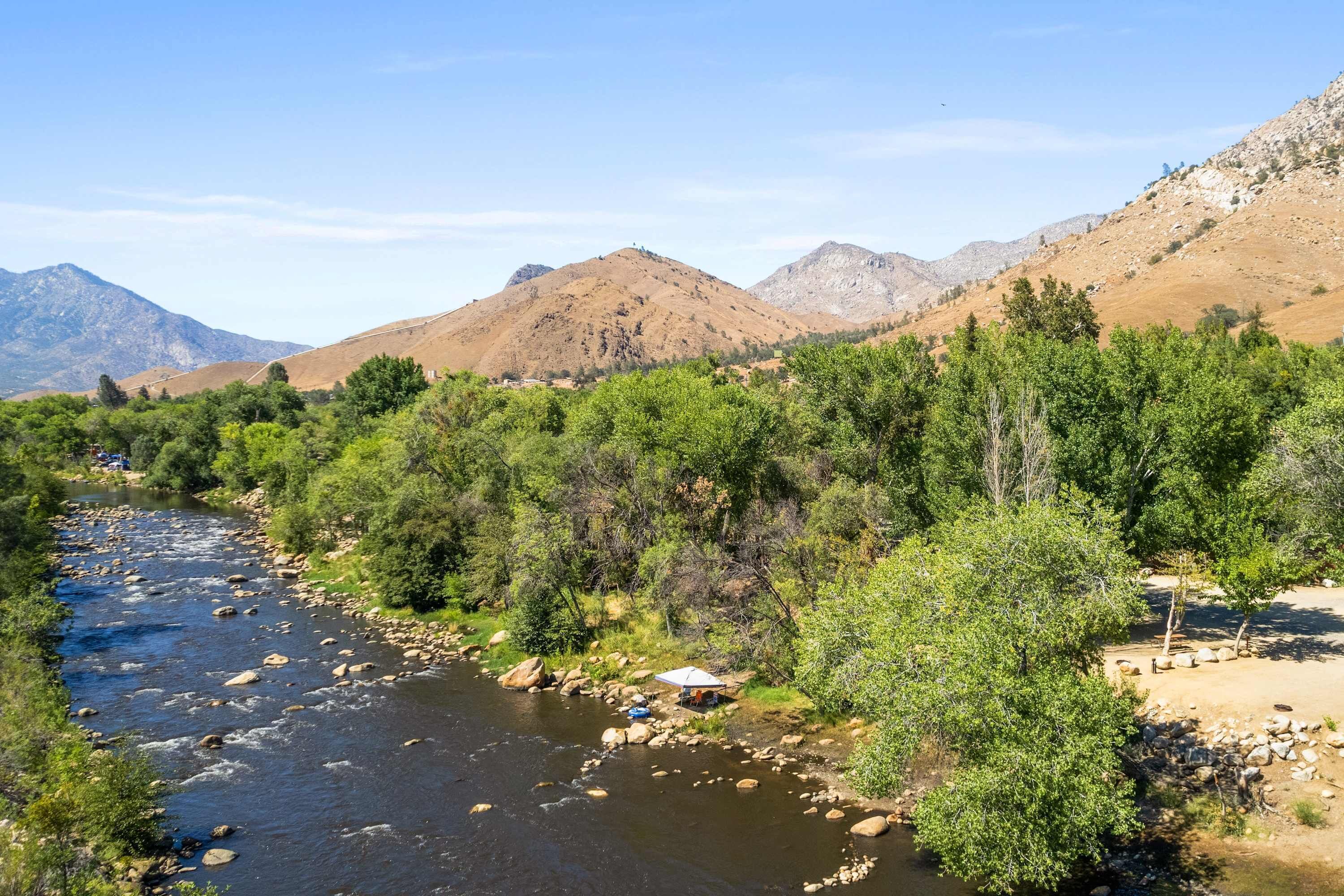 Un río serpentea a través de una zona montañosa, con abundante vegetación y terreno rocoso.