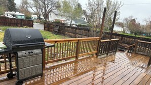 A wooden deck with a grill and a cart. - A newly renovated home full of fun games for the entire family to enjoy. (Thermopolis)