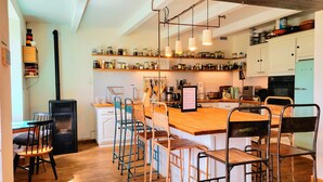 Une cuisine avec un îlot central, des tabourets de bar et une cuisinière.