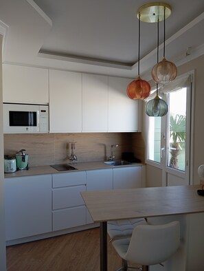 Een koelkast, een microgolfoven, een kookplaat, een vaatwasser