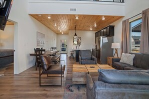 A spacious living area with a high ceiling, a dining area, and a kitchen. - Luxe Cabin W Indoor Pool・Spacious Cabin, Sleeps 10 (Sevierville)