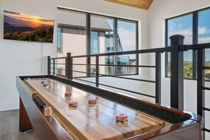 A shuffleboard table with pucks, a wooden bench, and a railing. - Luxe Cabin W Indoor Pool・Spacious Cabin, Sleeps 10 (Sevierville)
