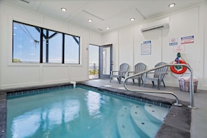A swimming pool with a clear view of the sky through large windows, a lifebuoy, and a sign indicating no lifeguard on duty. - Luxe Cabin W Indoor Pool・Spacious Cabin, Sleeps 10 (Sevierville)