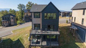 A two-story building with a balcony and outdoor seating area. - Luxe Cabin W Indoor Pool・Spacious Cabin, Sleeps 10 (Sevierville)