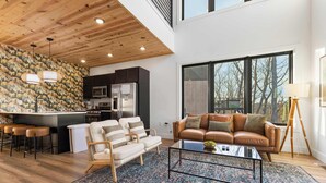 A modern living space with a kitchen, dining area, and seating.