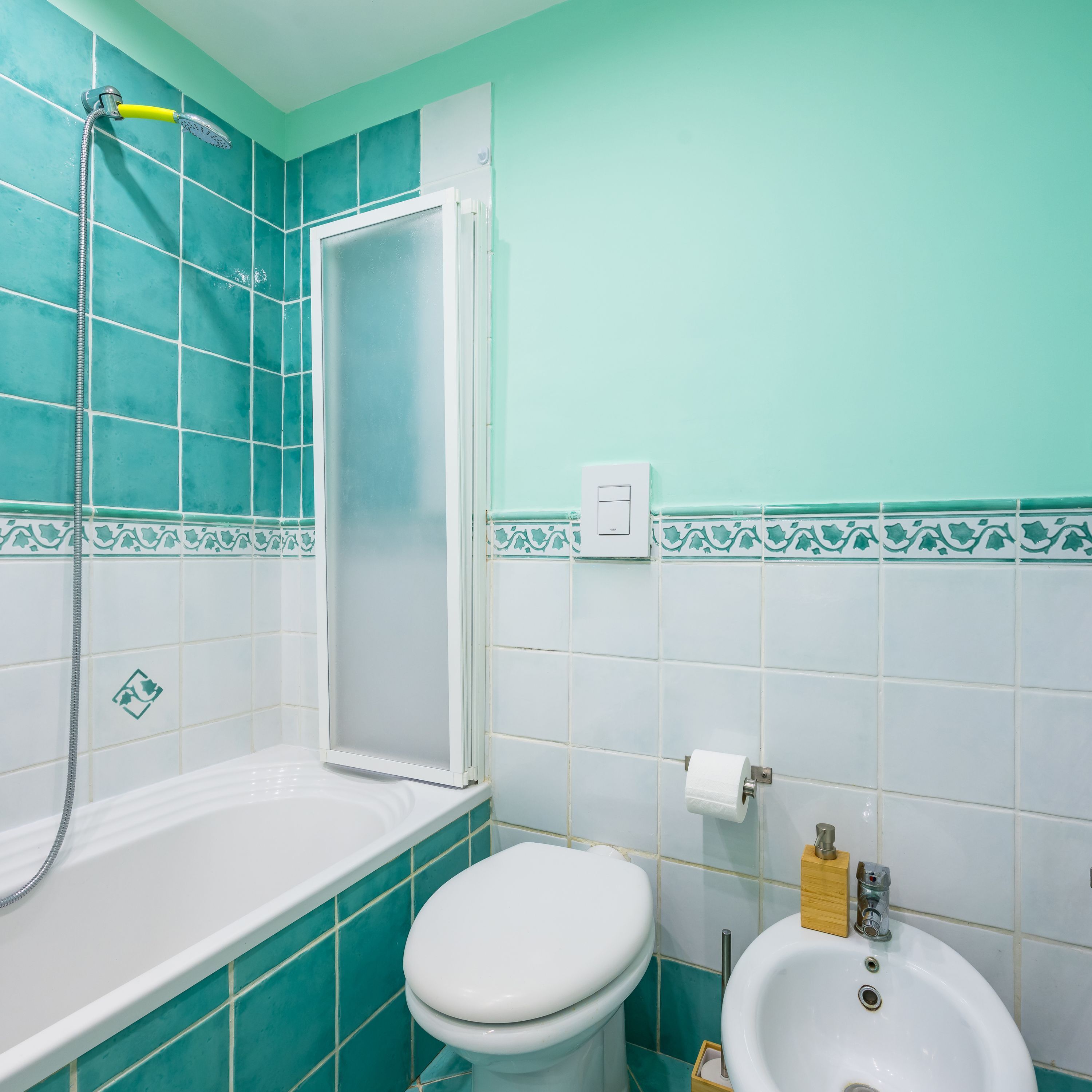 A bathroom with a shower, toilet, and sink.
