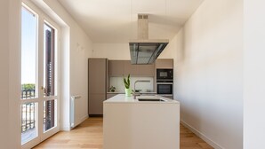 A modern kitchen with a central island, built-in appliances, and large windows. - Oretea Apartment With Terrace by Wonderful Italy (Palermo)