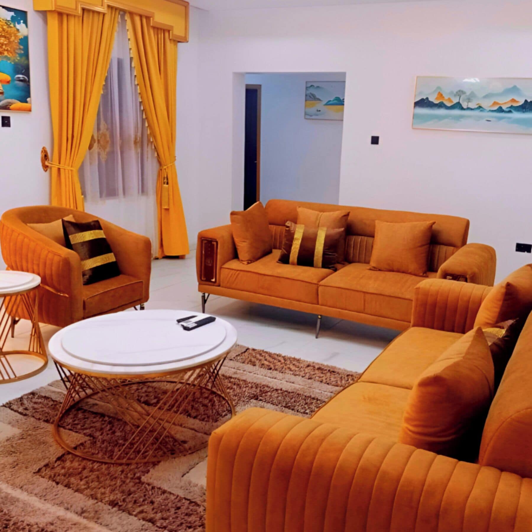 Un salon avec un canapé, des fauteuils, une table basse et un tapis.