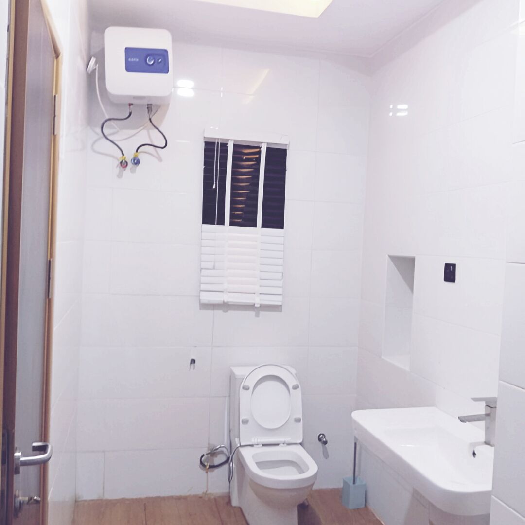 Un bagno con il water, un lavandino e una finestra con persiane.