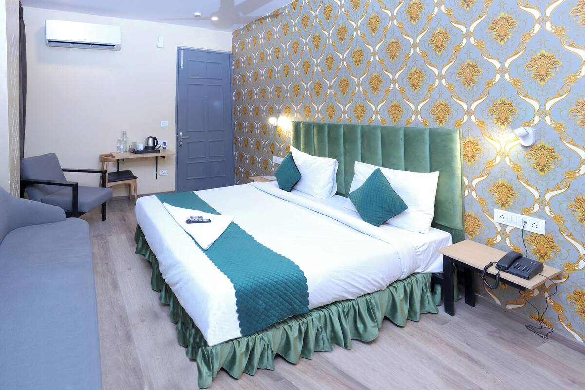 A hotel room with a bed, a desk, and a chair.