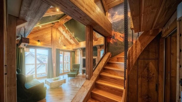 A wooden interior with a staircase, wooden beams, and large windows. - Mountain Shelter Apartments (Zakopane)