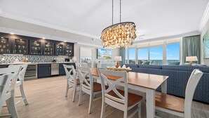 Une cuisine moderne avec des meubles de couleur sombre, un pare-feu en carrelage et un îlot central.