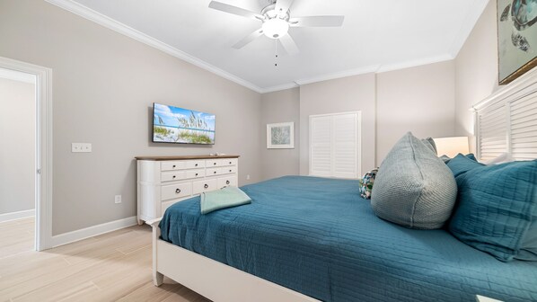 A bedroom with a bed, a dresser, a ceiling fan, and a television. - New Complex! BeachFront! Lazy River/Slide!! Parking Level!! (Orange Beach)