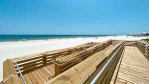 A wooden boardwalk leading to a beach with white sand and clear blue water. - New Complex!  BeachFront!  Lazy River/Slide!!  Parking Level!! (Orange Beach)