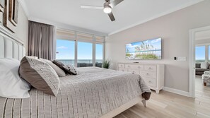 A bedroom with a large bed, a ceiling fan, a dresser, and a TV on the wall. - New Complex!  BeachFront!  Lazy River/Slide!!  Parking Level!! (Orange Beach)