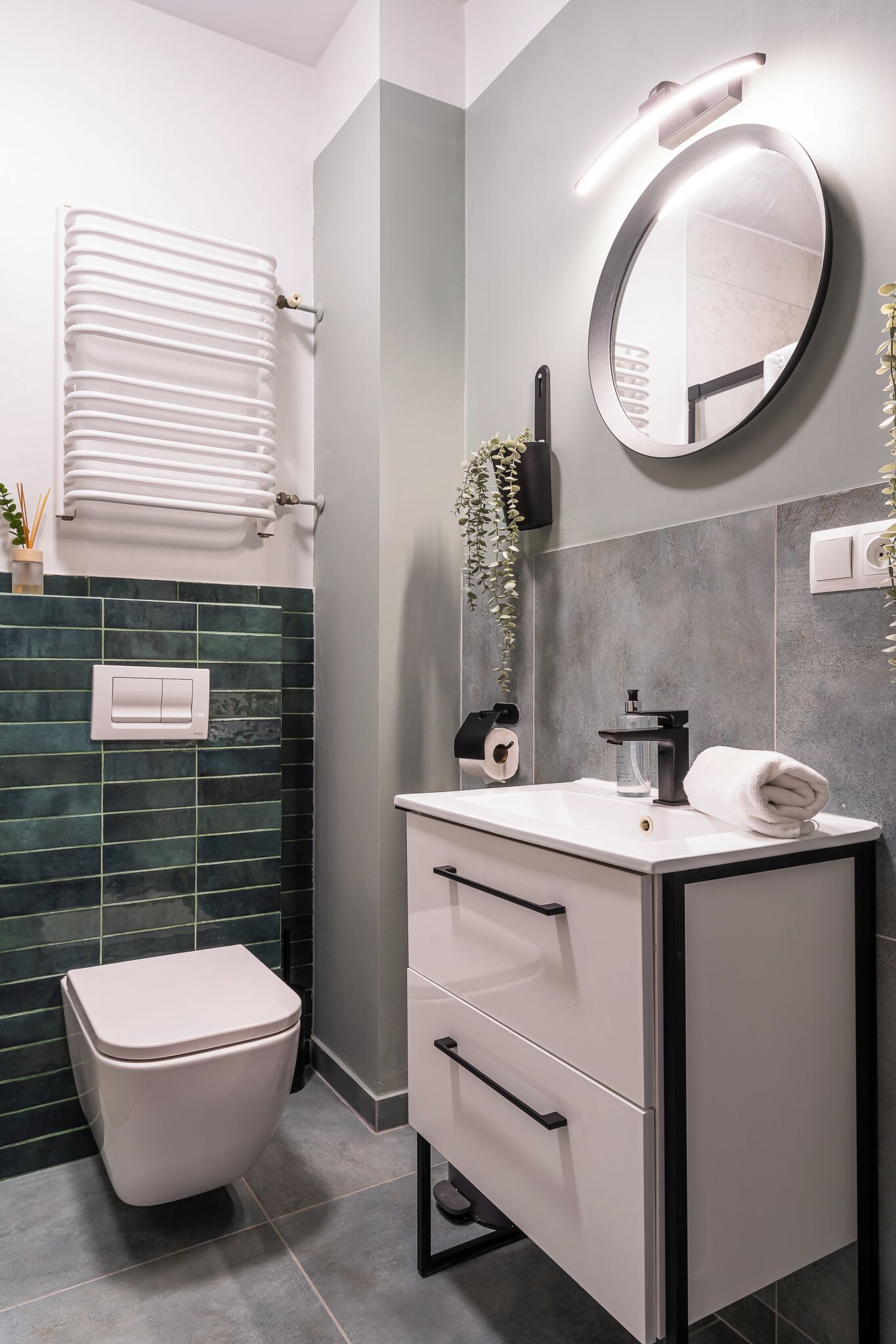 Un bagno moderno con il water, lavandino e specchio.