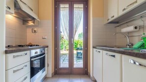 Eine Küche mit Herd, Backofen und Spüle, mit Blick ins Freie.