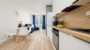 Une cuisine moderne avec un plan de travail en bois, des armoires blanches et un évier noir.
