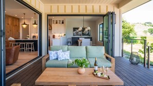 Un salon confortable avec un canapé, une table basse en bois et une vue sur la cuisine et la salle à manger.