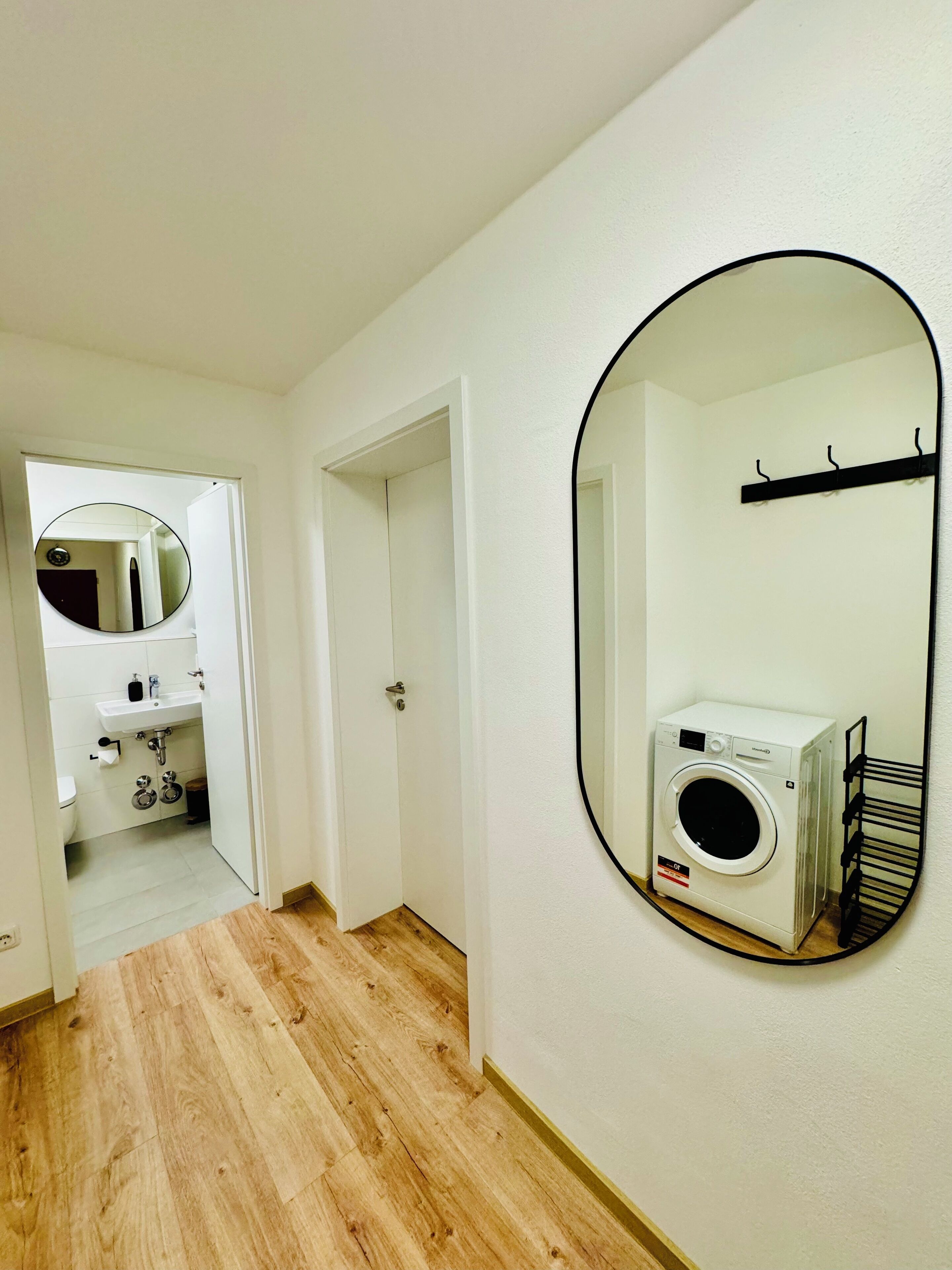 Welcoming hallway with a large mirror, adding brightness and a touch of elegance