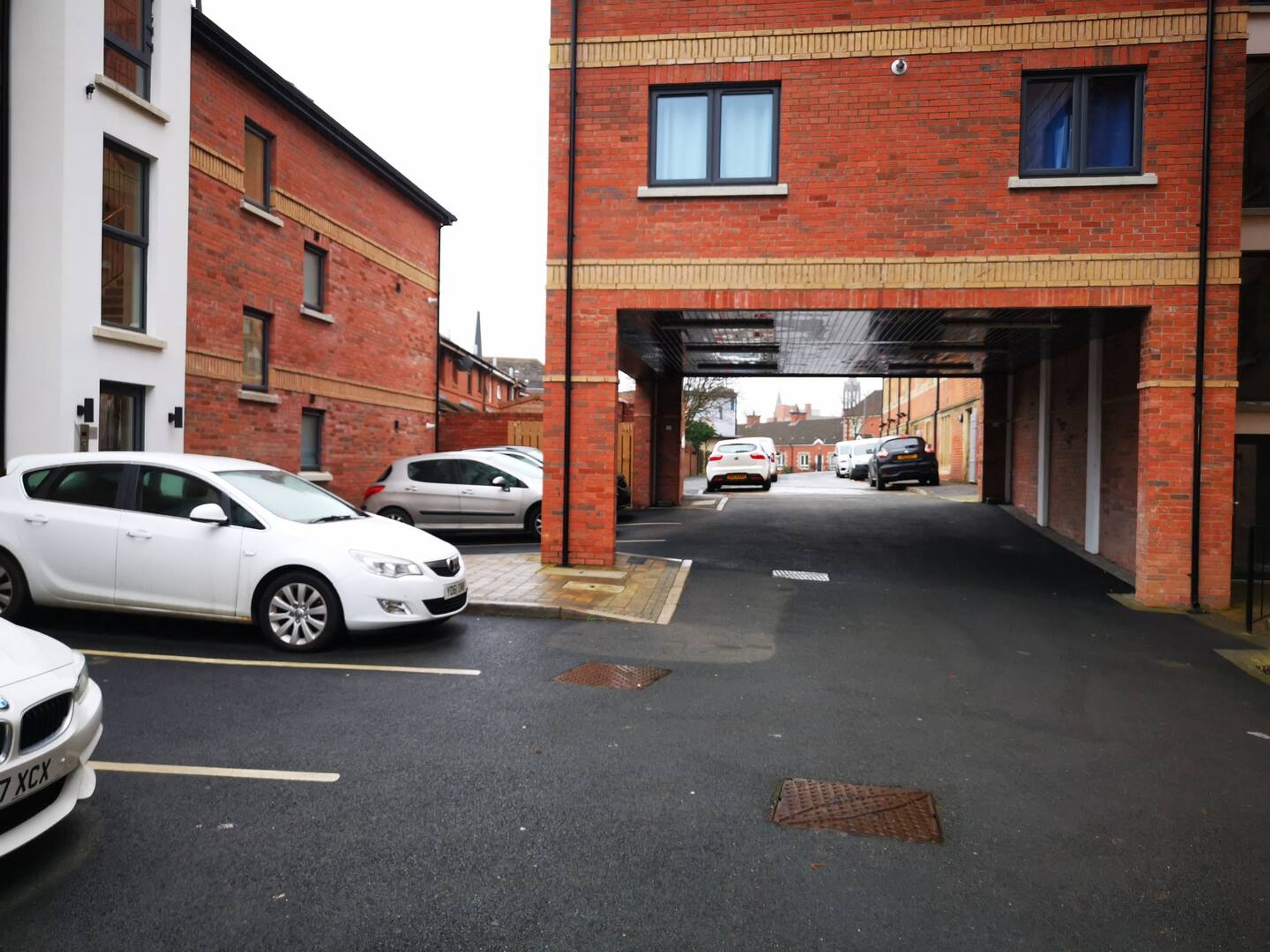 A parking garage with cars parked under an overpass.