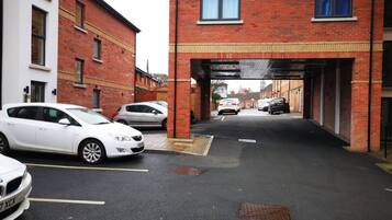 A parking garage with cars parked under an overpass.