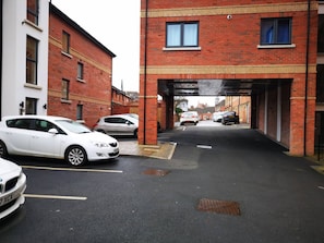 Un parking où des voitures sont garées sous un pont.