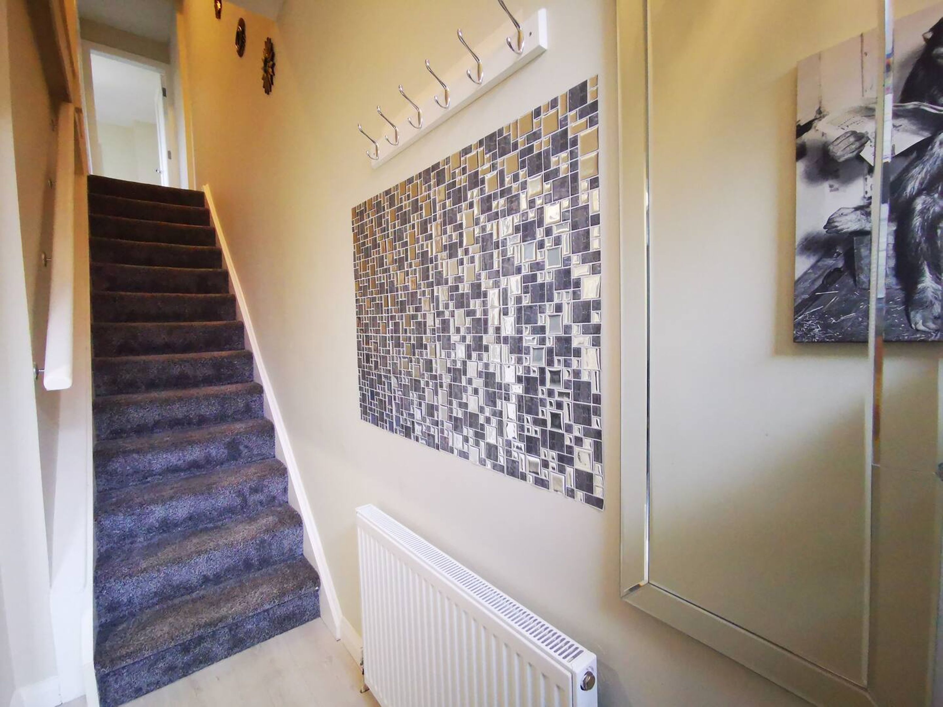 A staircase with a carpeted handrail leading to a landing.