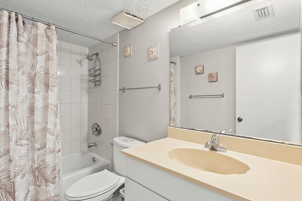A bathroom with a bathtub, toilet, and sink. - Oceanfront Ground Floor 3BR Steps To Pool and Beach Access! (St. Augustine)