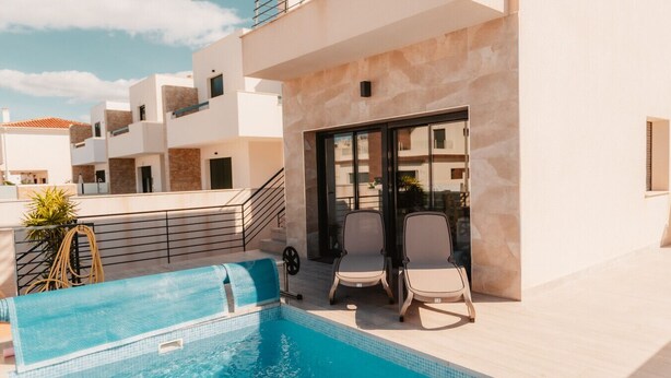 A rooftop pool area with a clear view of the sky, a pool, and two lounge chairs. - Villa Armonia - Heated Pool - Countryside Charm - by OYOOSTAYS (Daya Nueva)
